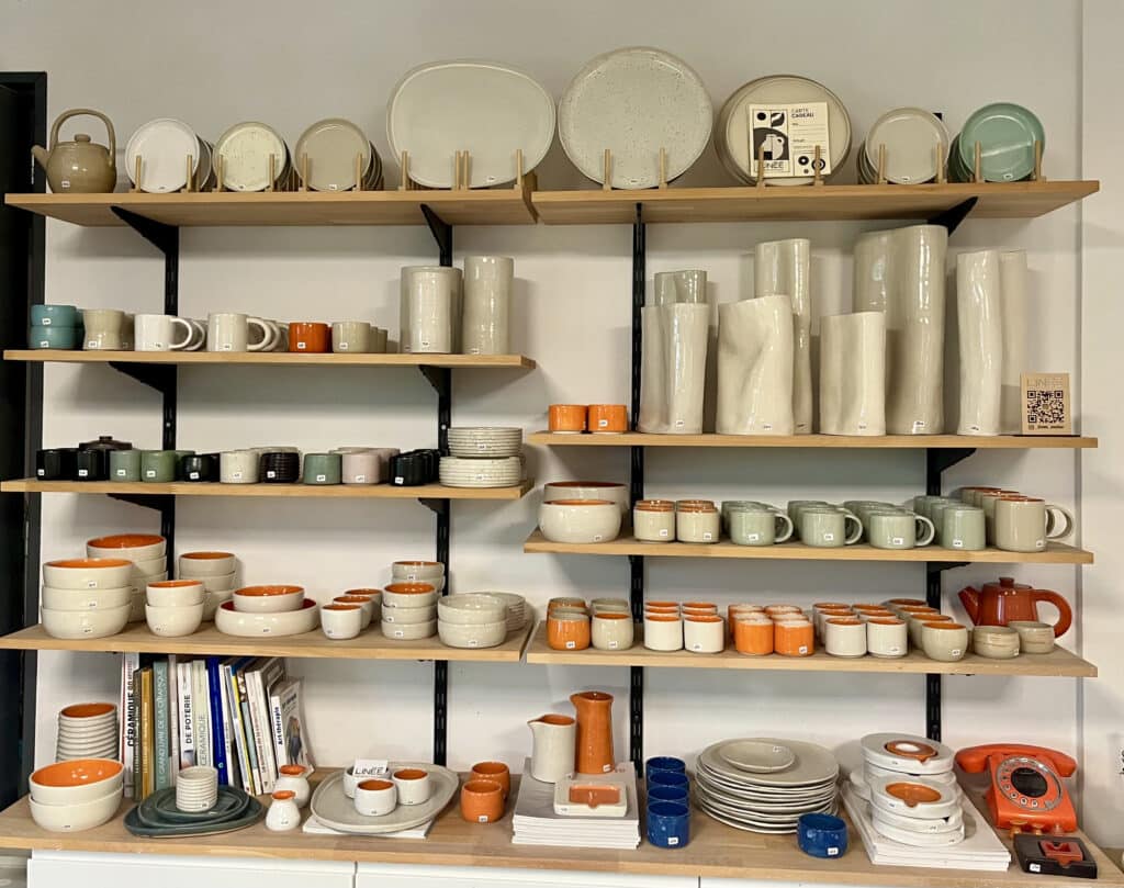 Pièces en céramique exposées dans un atelier de poterie après cuisson et émaillage.