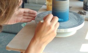 Dégradé de peinture bleue réalisé par une céramiste sur une pièce en argile lors d'une formation en céramique en Charente