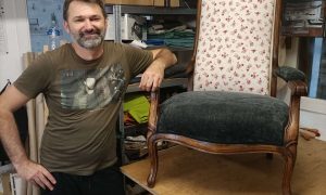 Stagiaire posant à côté d’un fauteuil restauré lors d’une formation tapissier à Montpellier