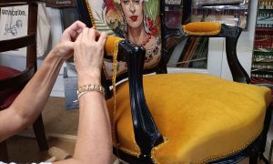 Apprenant travaillant sur la finition d'un fauteuil rénové pendant une formation tapissier à Montpellier
