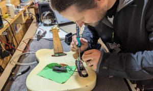 Travail de finition sur une guitare Formation Luthier en guitare à Montpellier