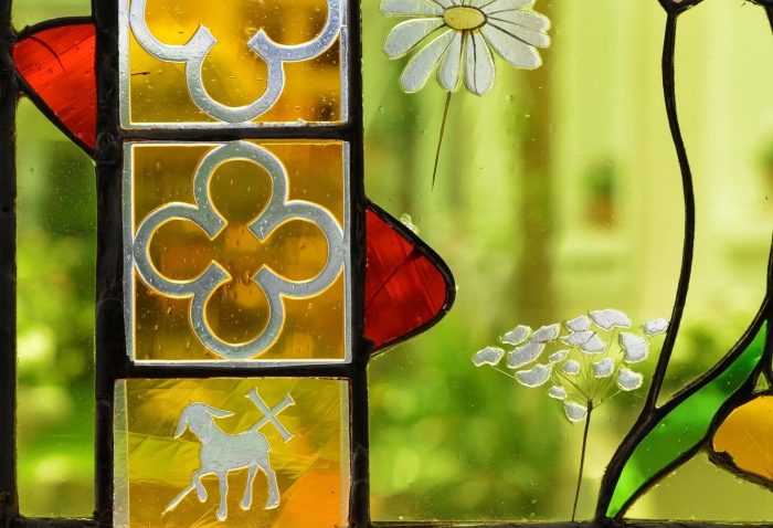 Détail d'un vitrail ancien restauré, motifs quadrilobés et agneau pascal, appris lors d'une formation vitrailliste CPF