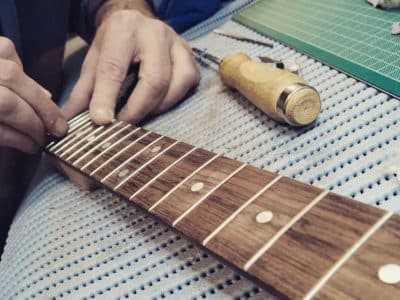 Entretien d'un manche de guitare au cours de la formation luthier en Normandie
