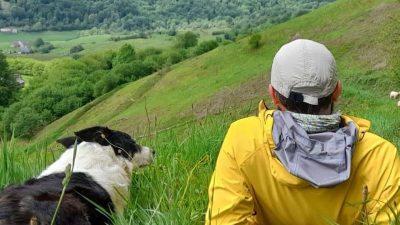 Participant avec un chien de berger face au paysage des Pyrénées
