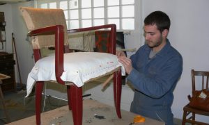 Stagiaire au cours de la formation tapisserie d'ameublement avec un tapissier garnisseur à Nantes