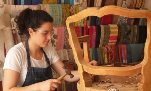Stagiaire au cours de la formation tapisserie d'ameublement avec un tapissier garnisseur à Nantes