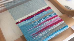 Tissage sur métier à tisser dans l'atelier d'une artisane tisserand pendant un stage ou des cours